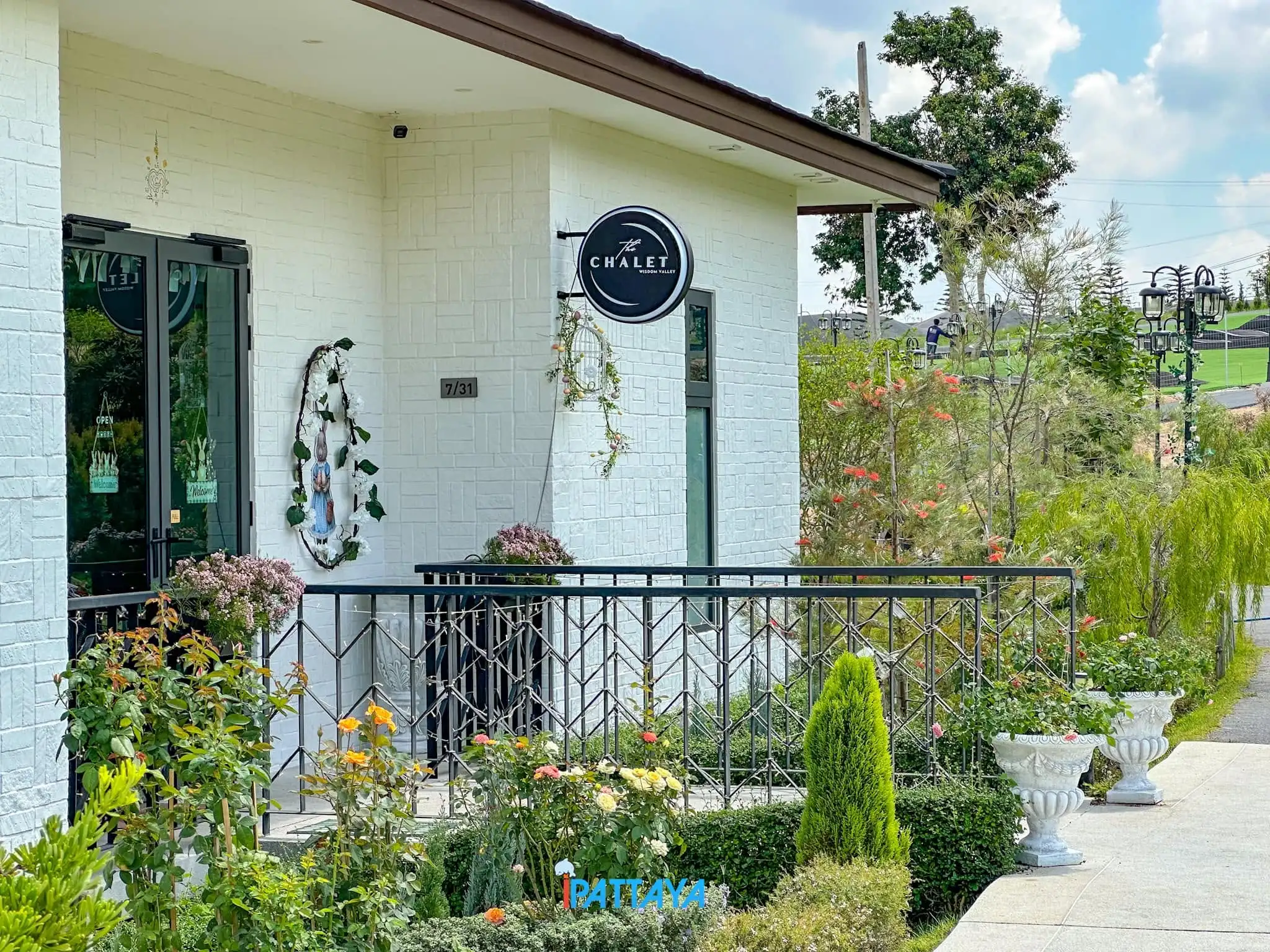 The chalet-style facade of the cafe framed by garden greenery